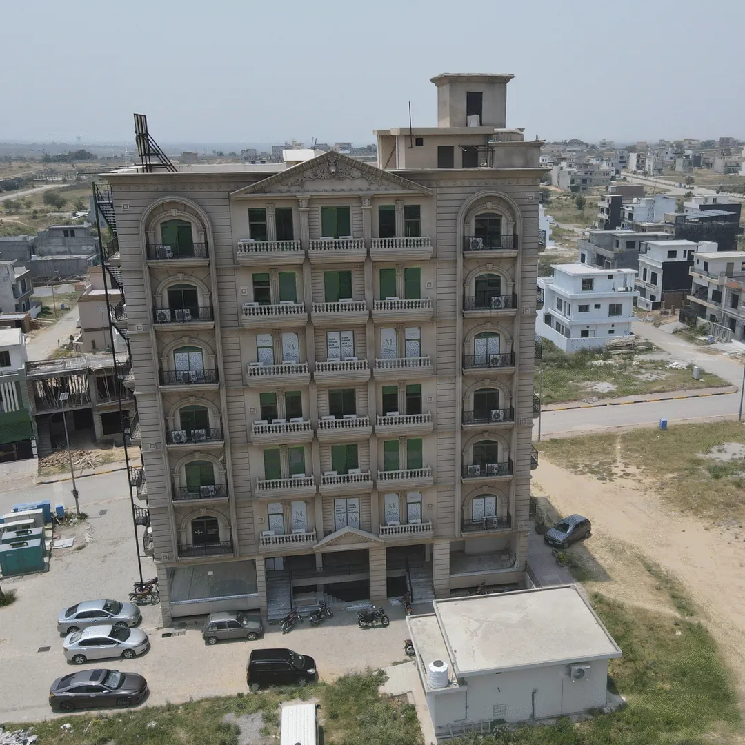 A completed building with cars parked beside it