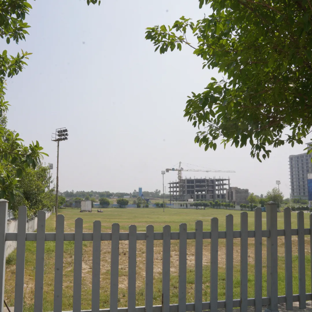 A cricket ground behind a fence