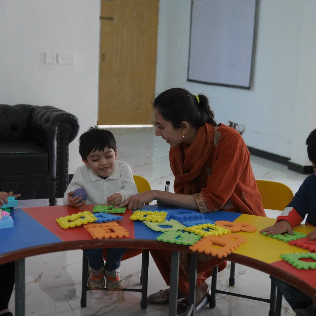 A teacher and a child at a table in a classroom